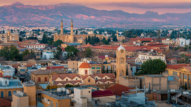 Blick auf eine Stadt mit historischen Gebäuden mit Bergen im Hintergrund