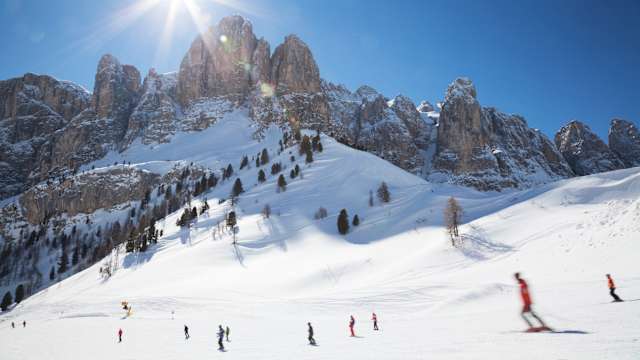 Skifahrer in den Dolomiten bei strahlendem Sonnenschein © iStock.com/nicolamargaret