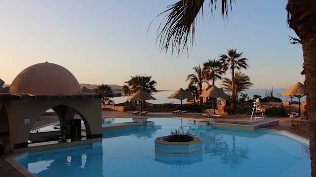 Blauer Pool und Hotelanlage mit Palmen vor dem Meer im El Quseir in Ägypten