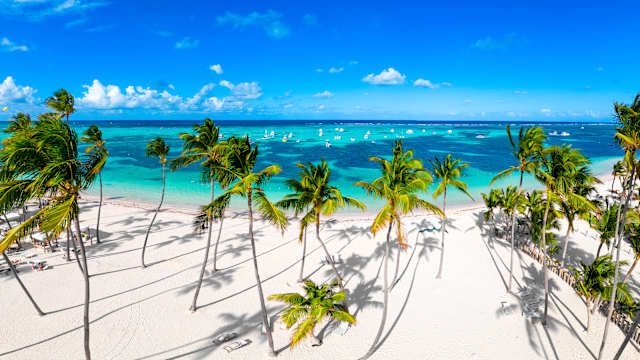 Boote im Meer und Palmen am Bavaro-Strand, Dominikanische Republik.