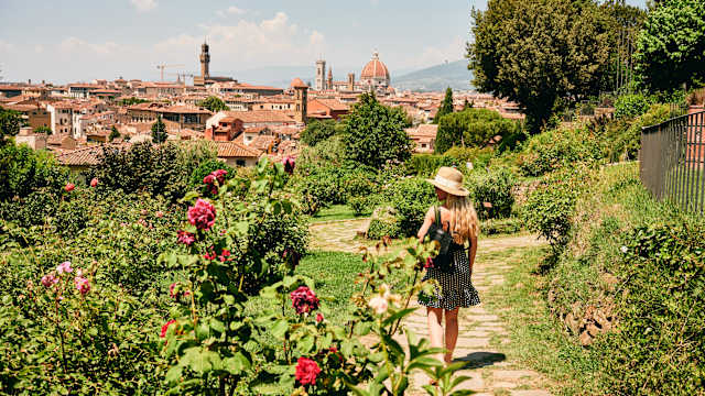 Eine Frau läuft durch einen Blumengarten in Florenz, Italien.