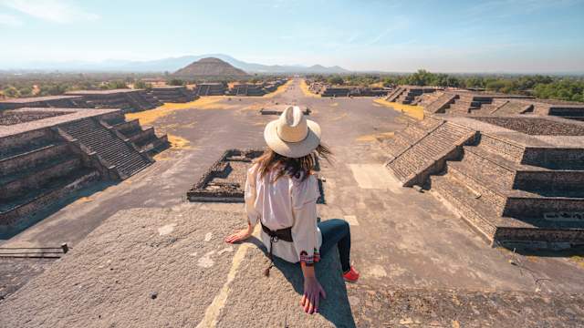 Eine Frau sitzt in der archäologischen Stadt Teotihuacan, Mexiko.