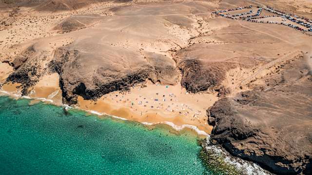 Menschen an einem Strand zwischen Felsen auf Lanzarote, Kanaren, Spanien.