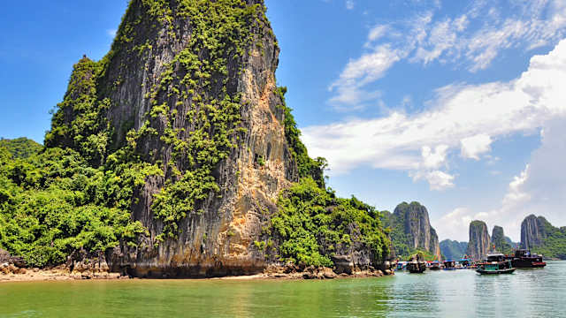 Riesiger Felsen und Boote an der Halong Bay, Vietnam.