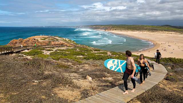 Surfer laufen von der Praia da Bordeira an der Westküste der Algarve, Naturpark Südwest-Alentejo und Costa Vicentina, Faro, Portugal