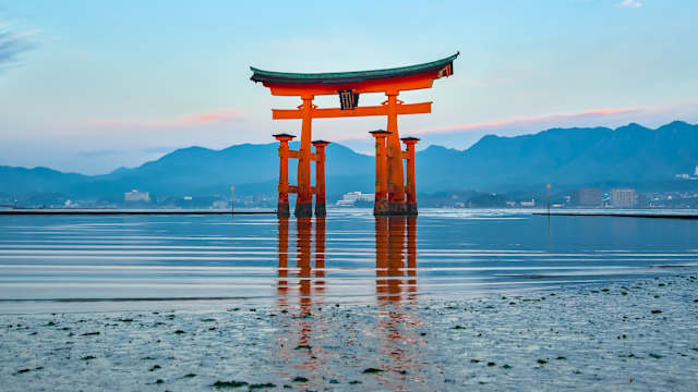 Ein großes, japanisches Schreintor im Wasser an der Küste.