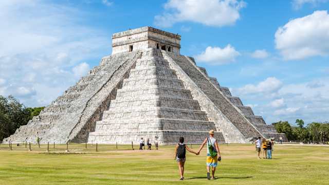Einige Touristen vor dem El Castillo Tempel in Yucatan, Mexiko.