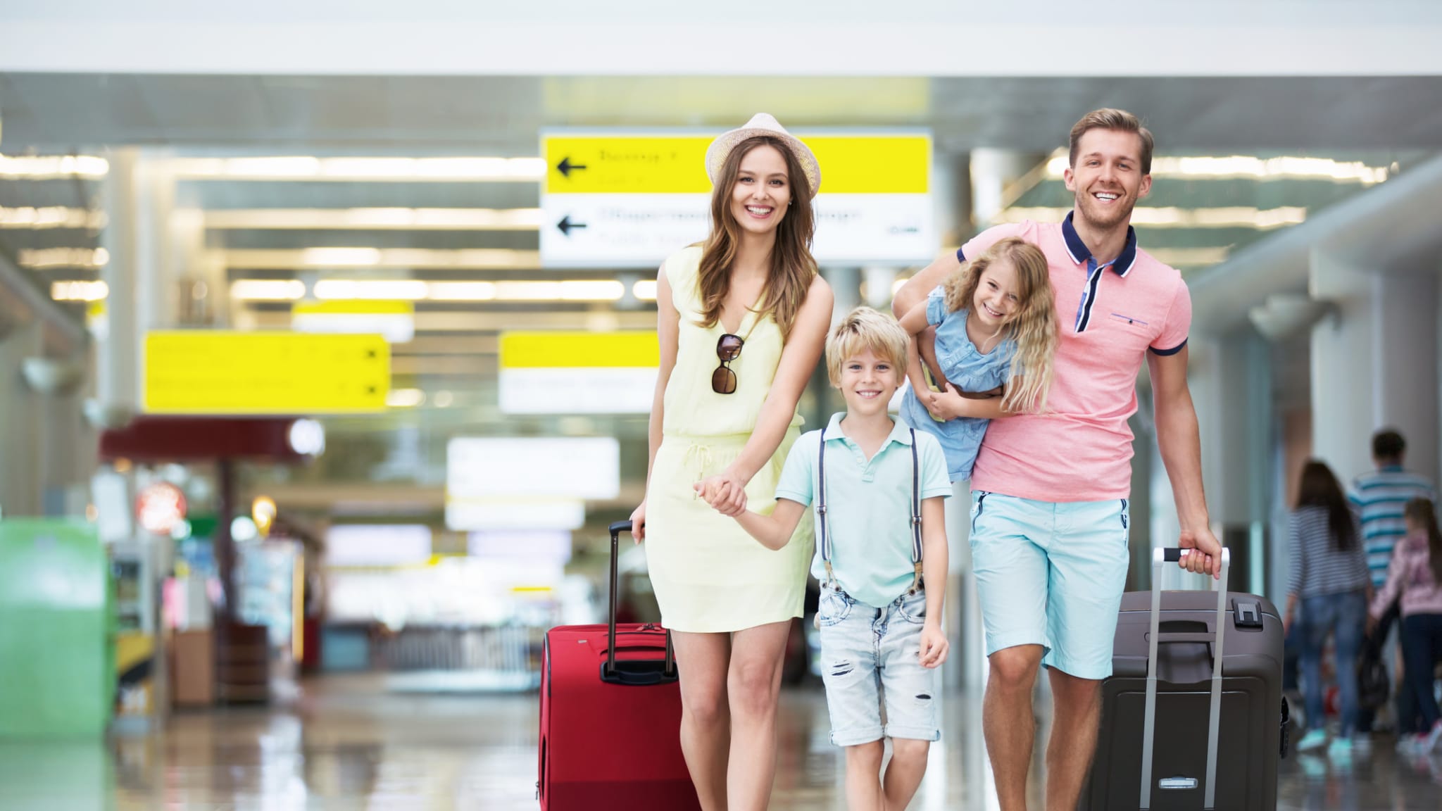 4 Personen Familie läuft mit Koffern durch den Flughafen © iStock.com/Deklofenak