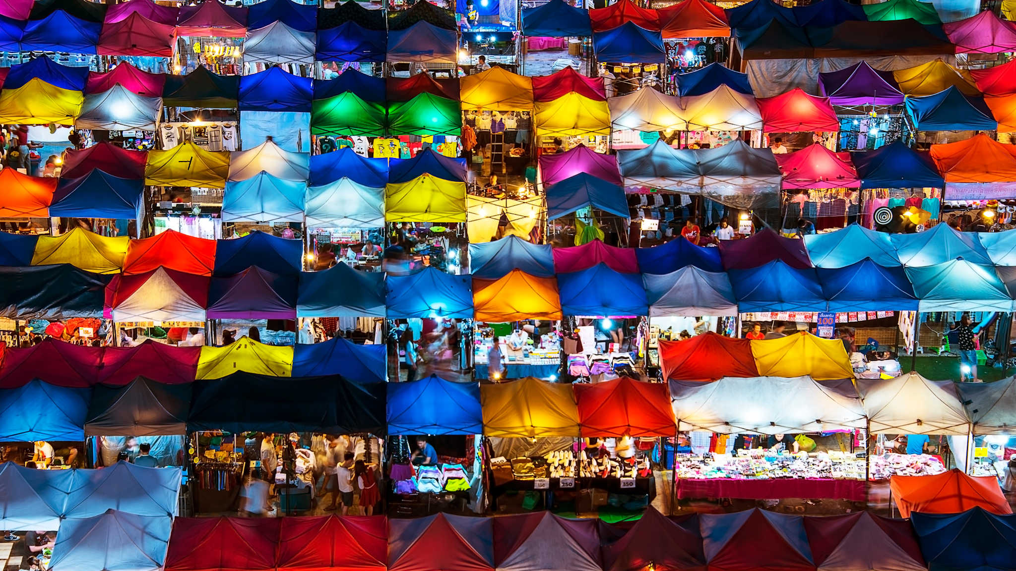 Bunte Stoffdächer von Marktständen auf dem Nachtmarkt von oben gesehen.