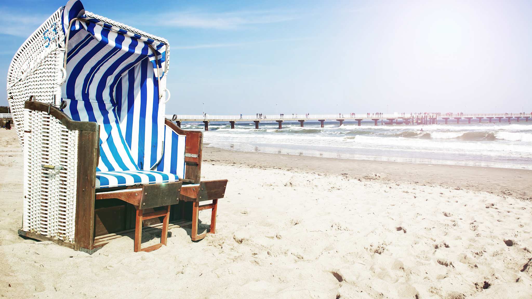 Gemütlicher blauer Strandkorb steht direkt am Meer © Getty Images