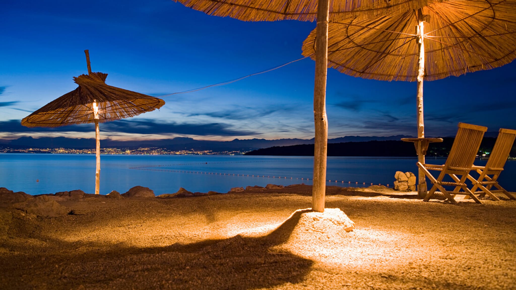 Beleuchtete Sonnenschirme in einer Strandbar, Njivice, Kvarner Bucht, Insel Krk, Kroatien, Europa
