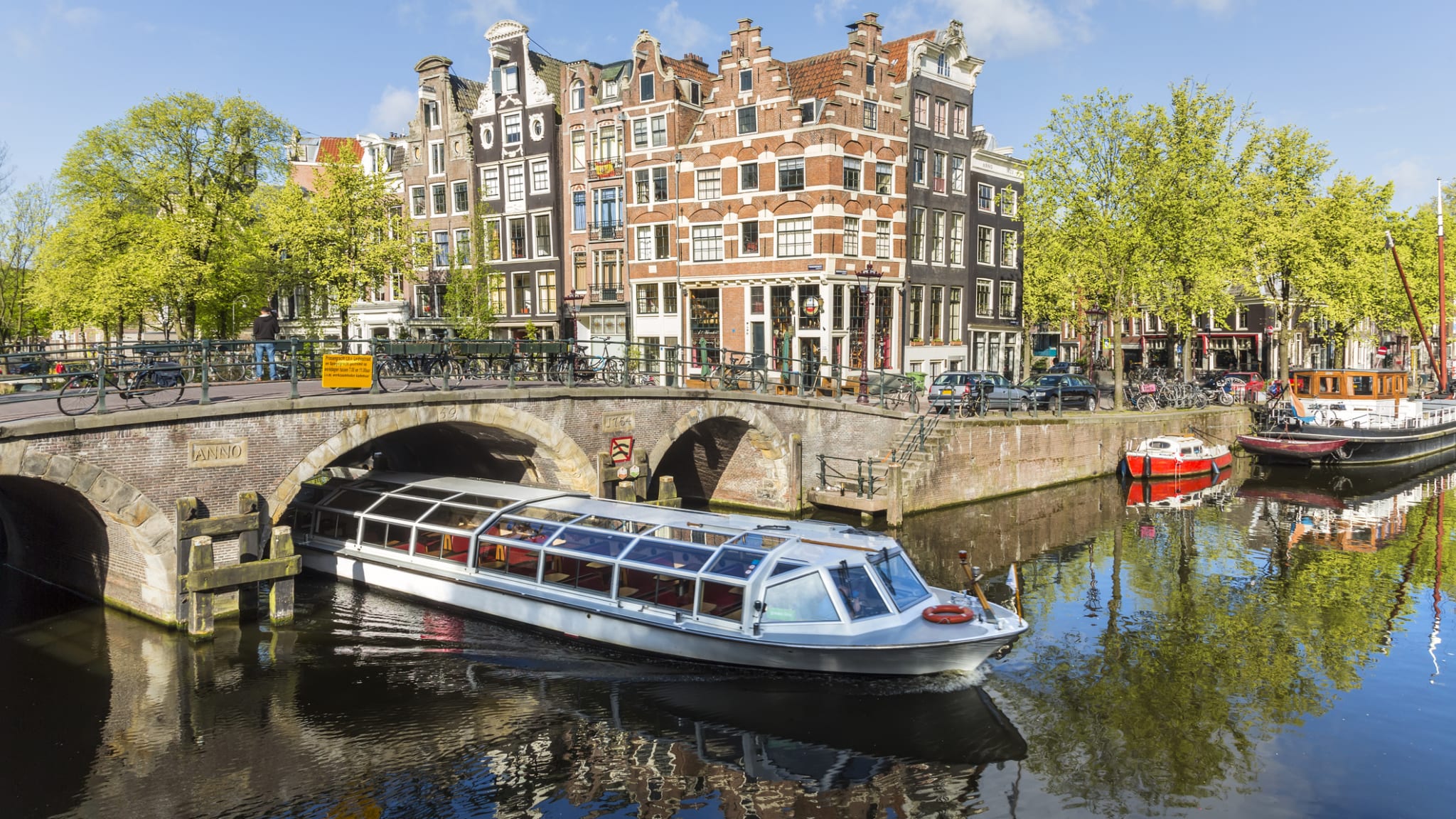Boot fährt durch den Kanal, Amsterdam, Niederlande © Peter Adams/Stone via Getty Images