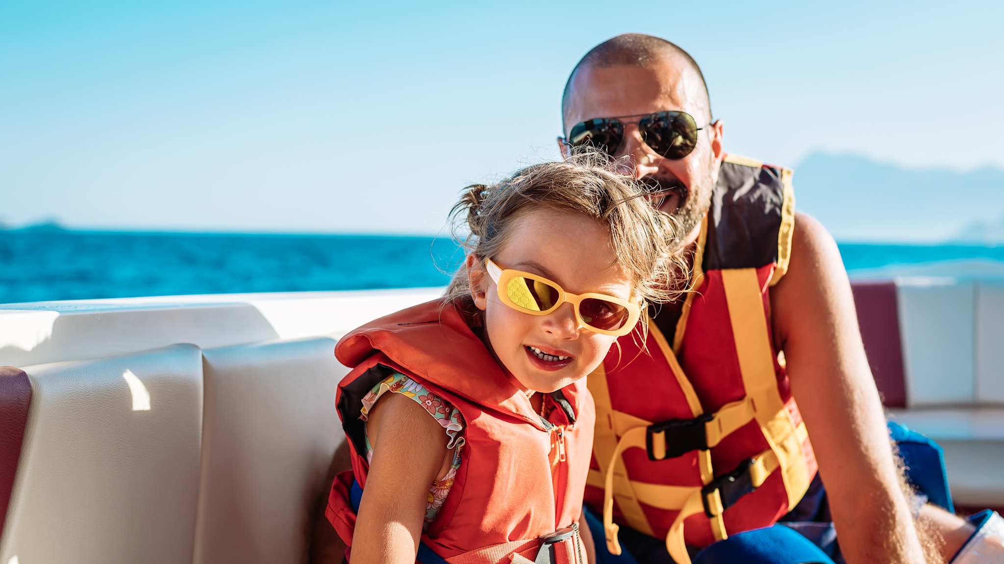 Mann und Kind in Rettungswesten auf einem Boot