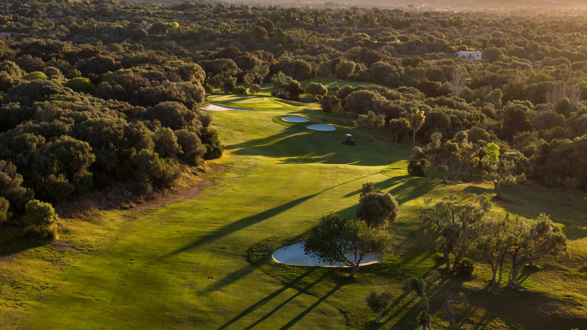 Luftaufnahme des Capdepera Golfplatzes, mit Bergen im Hintergrund und Bunkern im Grün