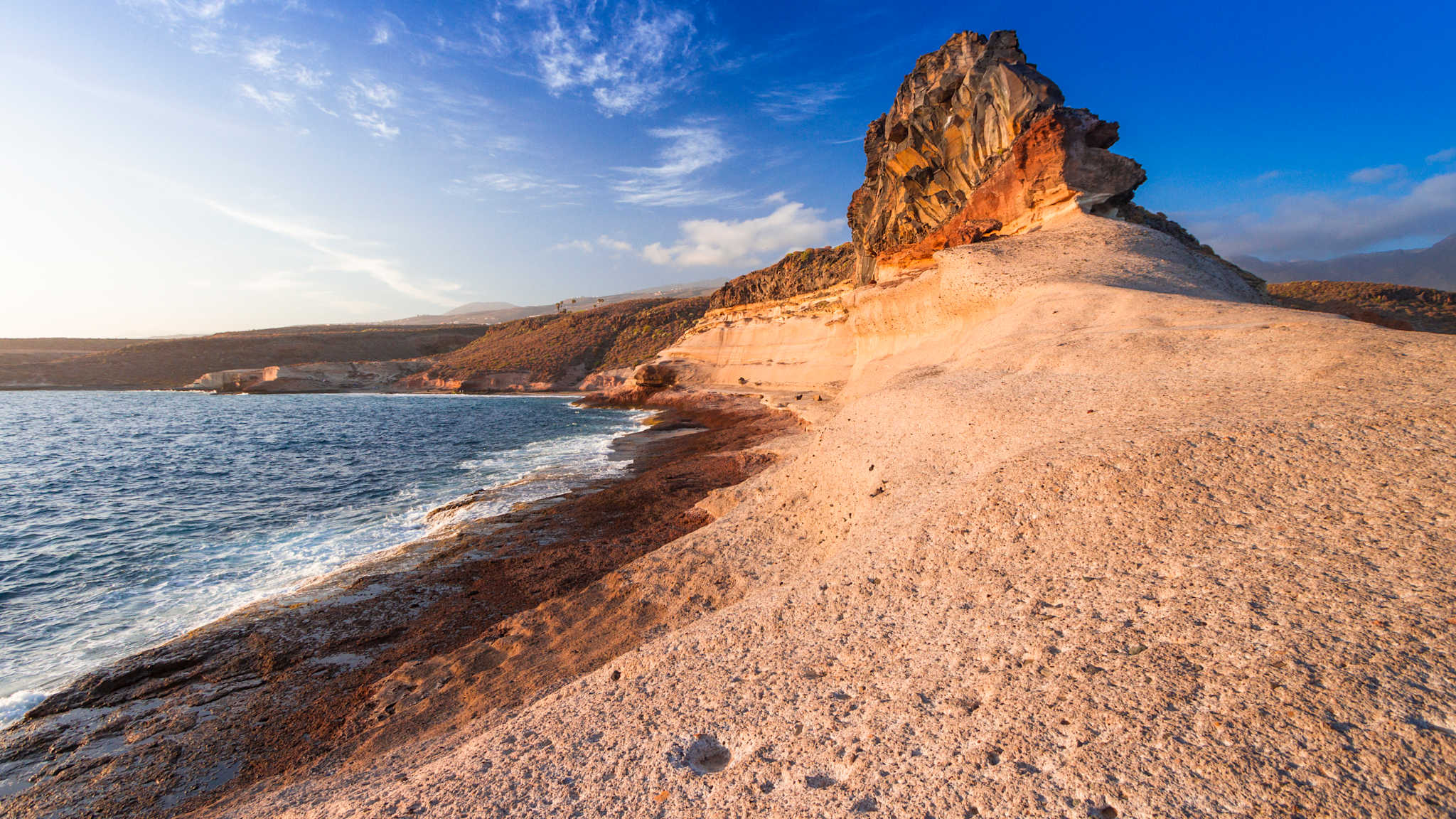 Ein leerer Strand, der sich in ein Gebirge aufbaut.