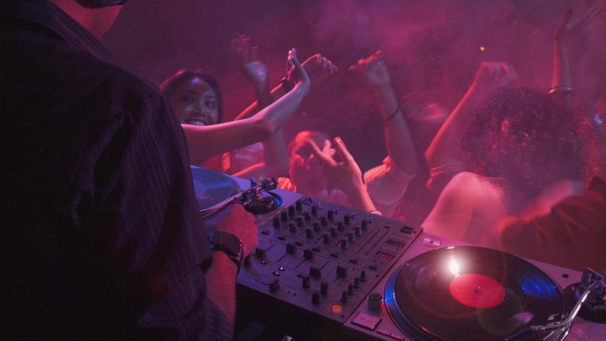 DJ legt für eine tanzende Menge auf. © PBNJ Productions/Tetra images via Getty Images