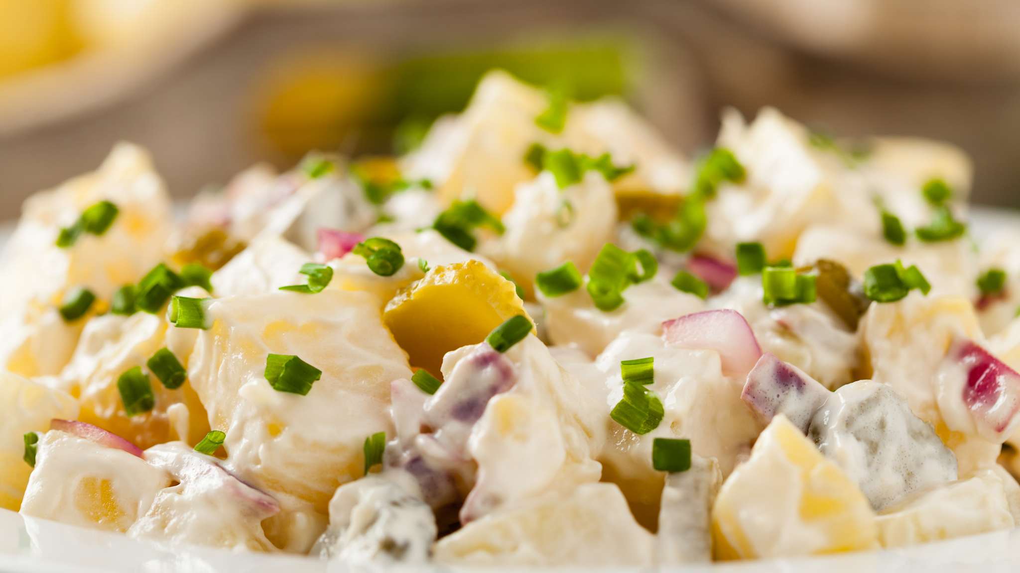 Eine Schüssel voller deutscher Kartoffelsalat mit Mayonnaise.