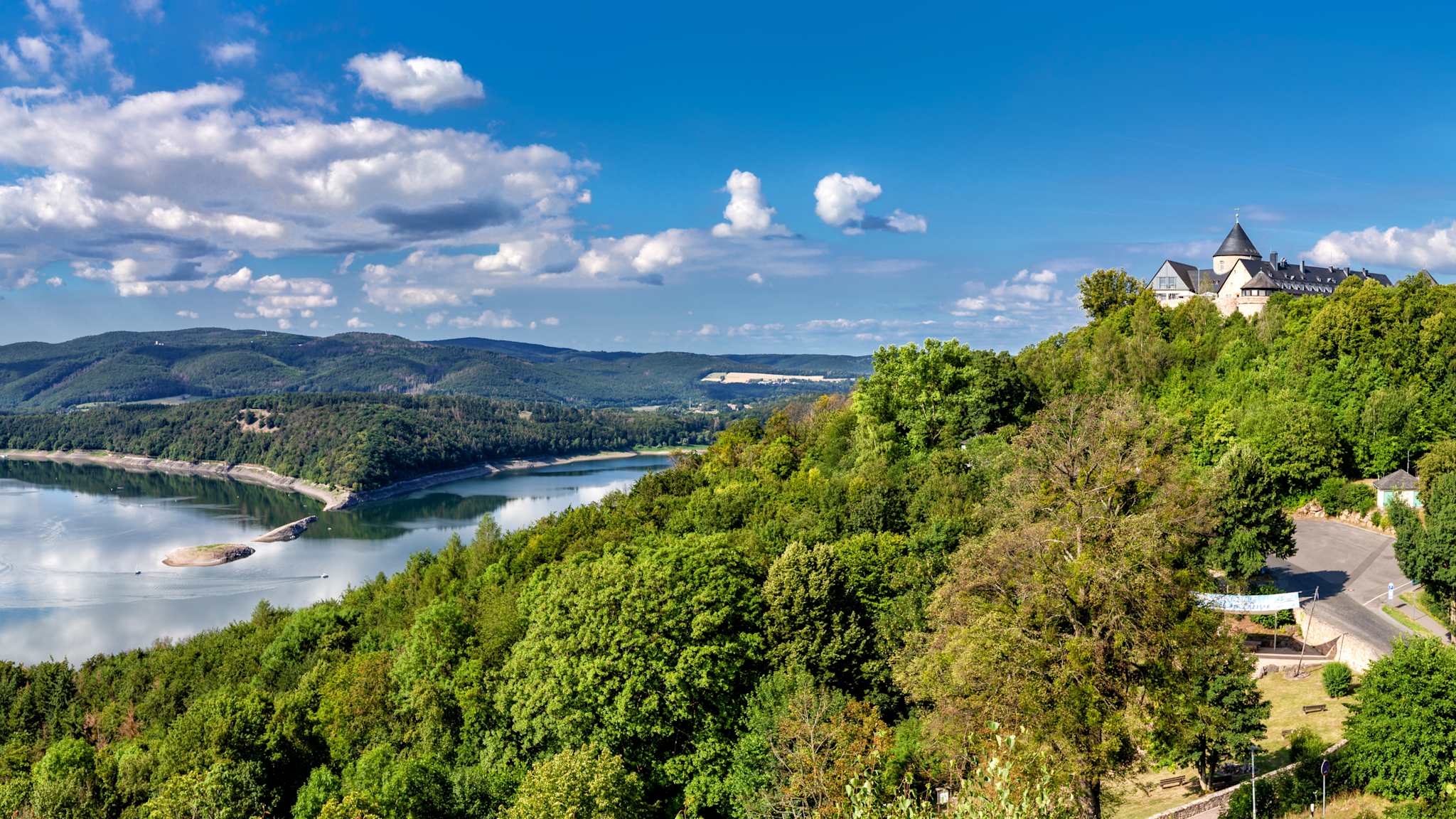 Der Edersee aus Vorgelperspektive mit Wäldern und Hügeln im Umkreis.
