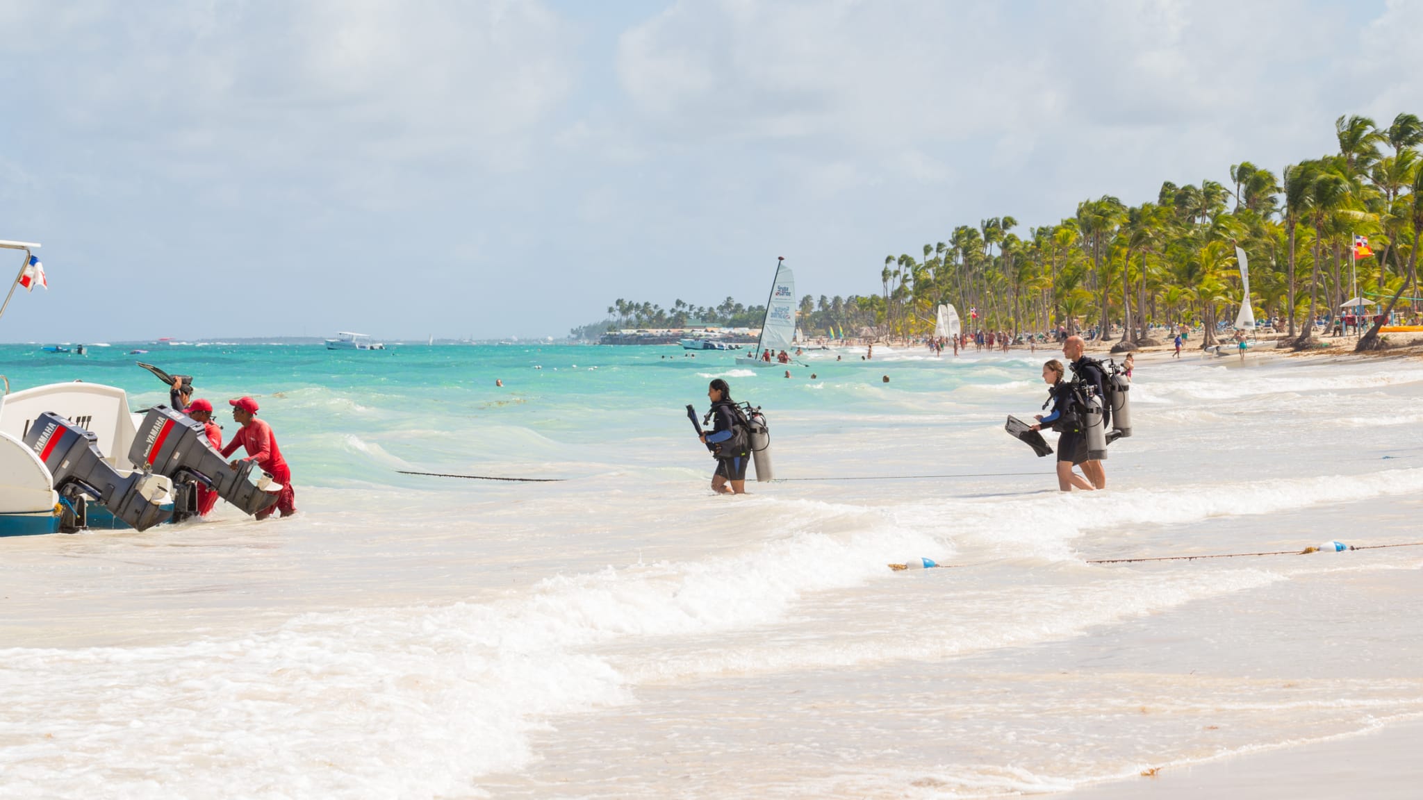 Eine Gruppe von Menschen, die zum Tauchen ins Meer gehen © iStock.com/ico_k-pax