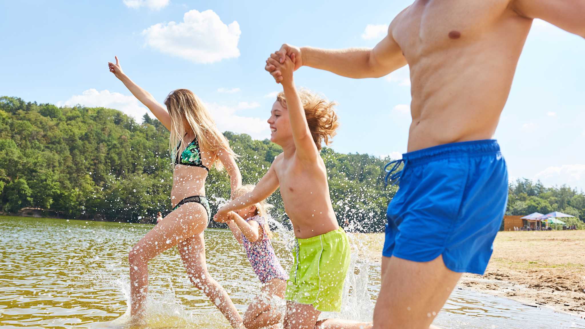Familie läuft ins Wasser an einem See