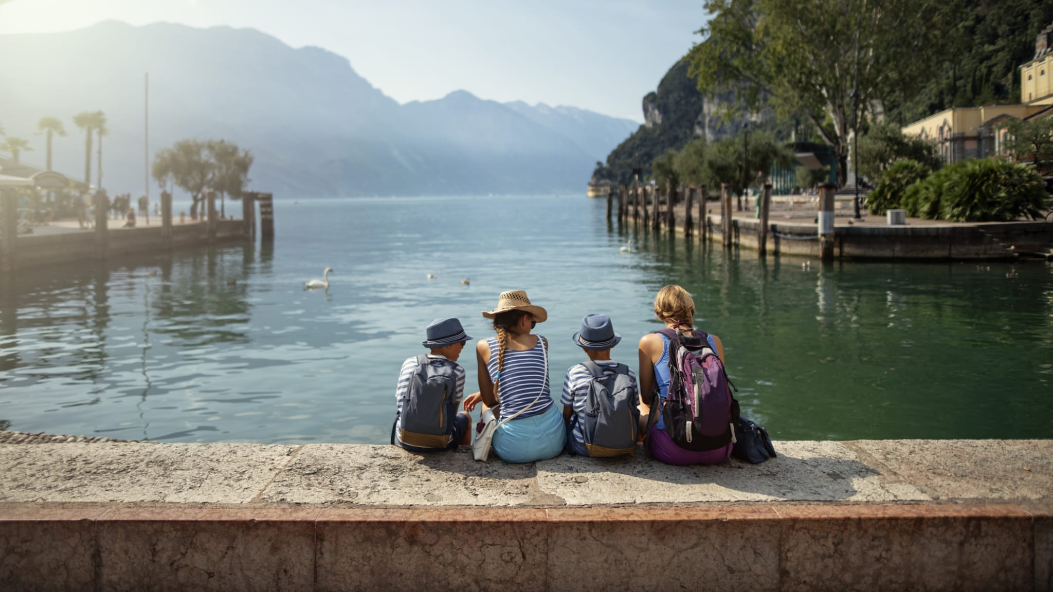 Familie sitzt am Hafen von Riva del Garda und schaut auf den Gardasee © iStock.com/1061876216
