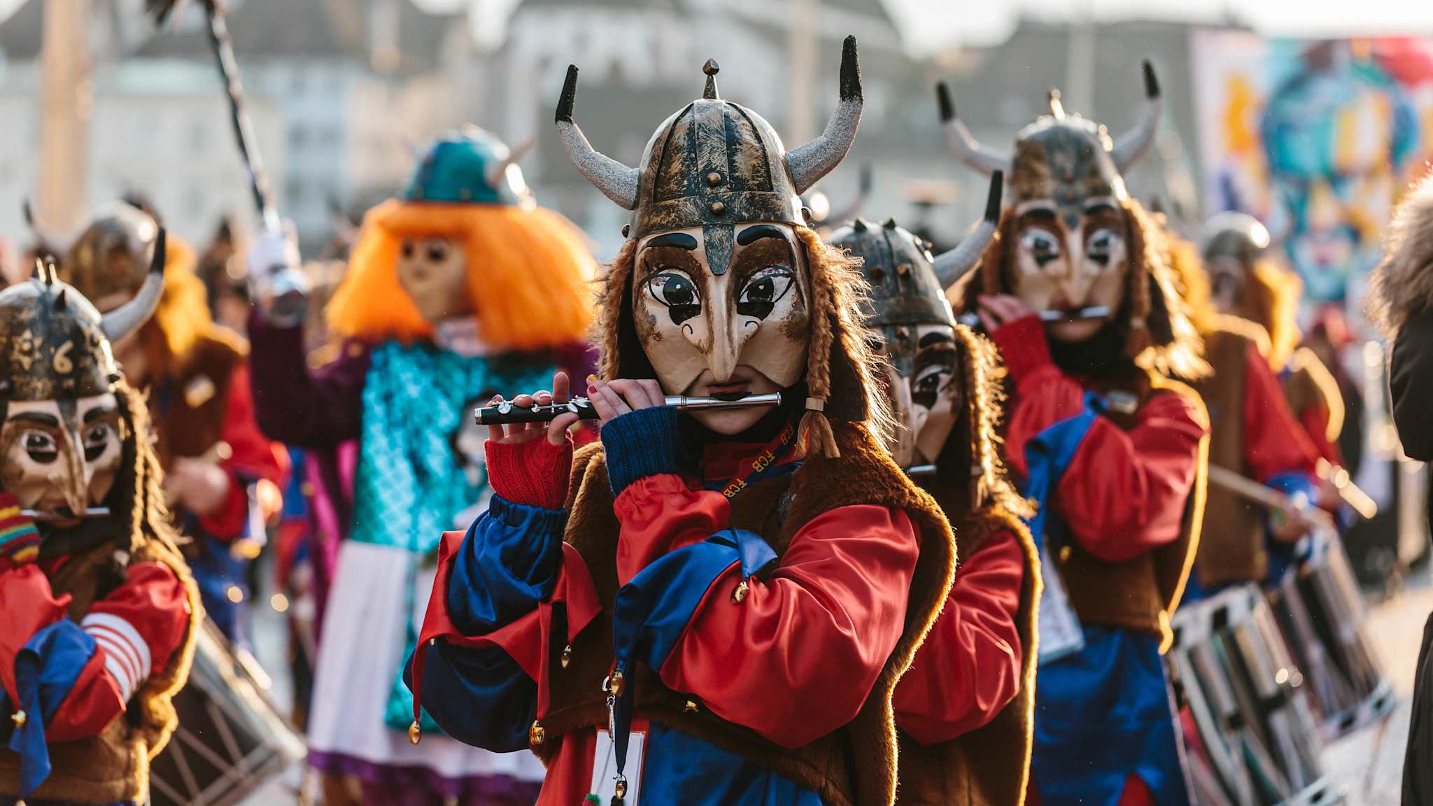 Ein verkleideter Karnevals-Verein zieht durch Basel und spielt auf Querflöten.
