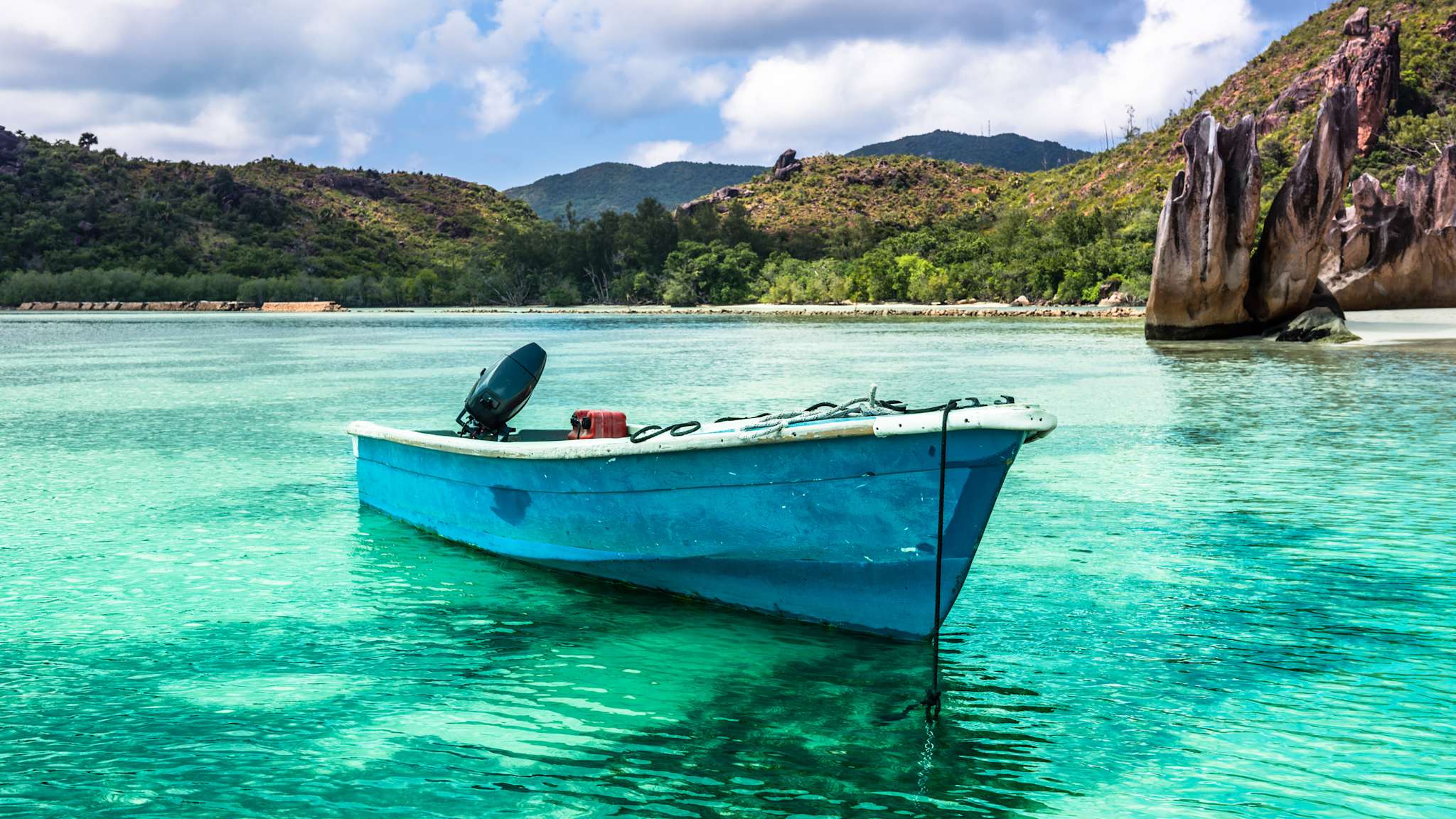 Fischerboot in einer Bucht mit türkisfarbenem Wasser