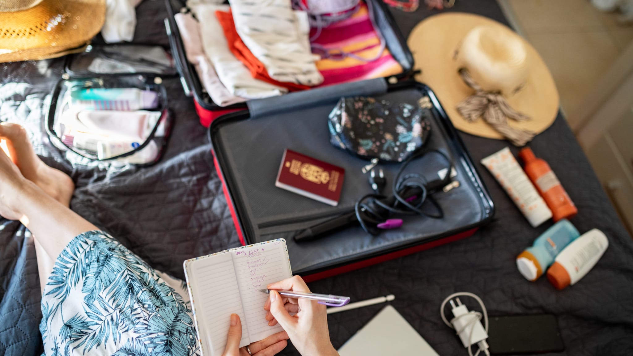 Frau prüft, ob sie alles eingepackt hat, was sie für den Urlaub braucht © iStock.com/BjelicaS