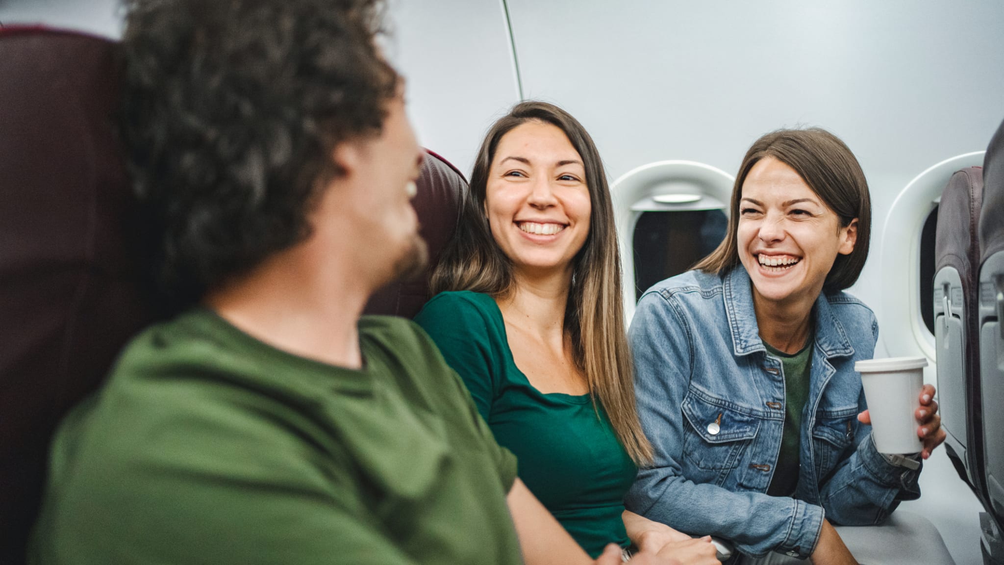 Freunde lachen im Flugzeug © gettyimages.de - Viktor Cvetkovic