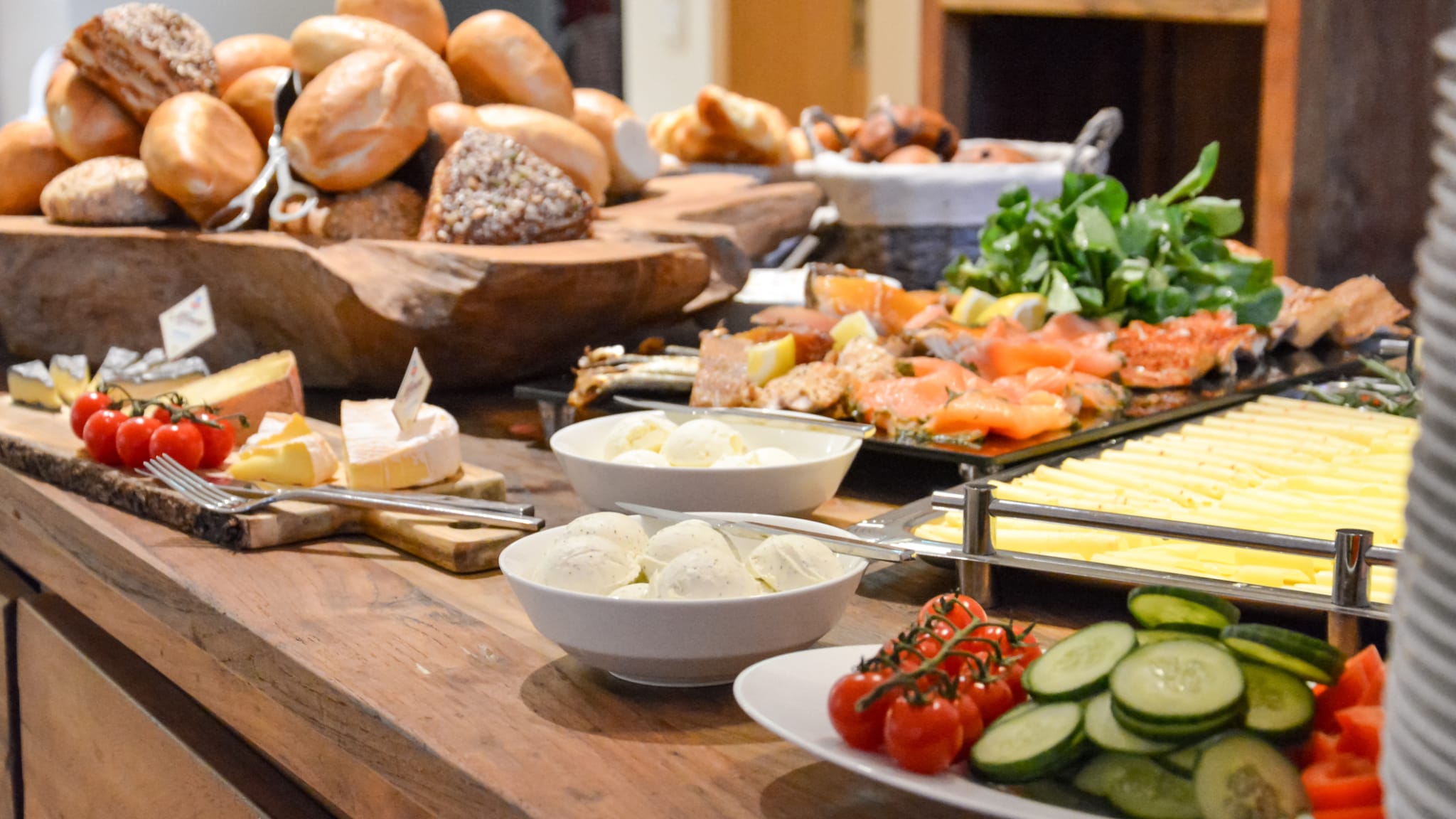 Ein Frühstücksbuffet mit Brötchen, Käse und mehreren Gemüsesorten ©Asvolas/iStock