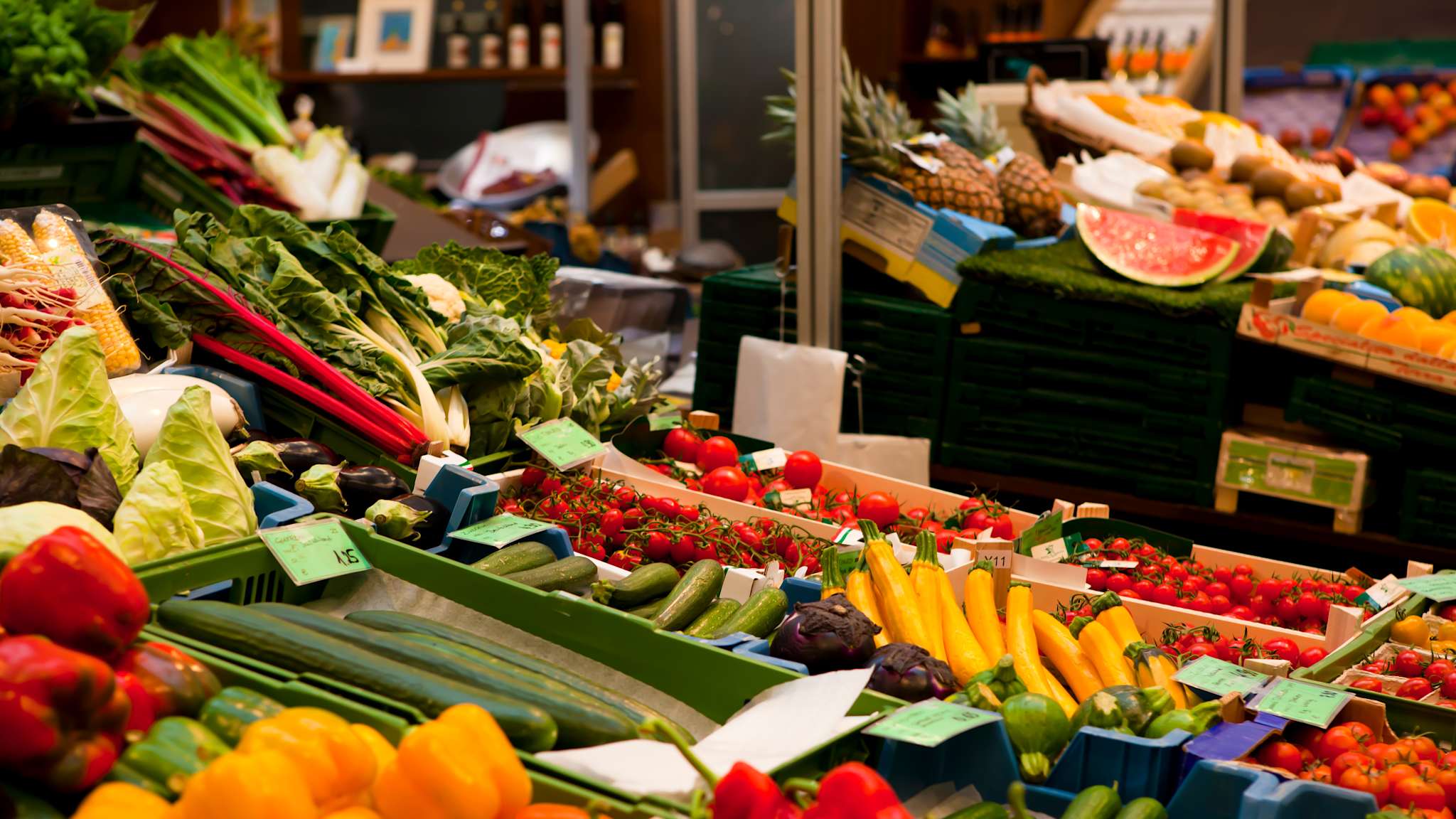 Marktstände voller Kisten mit frischem Obst und Gemüse.