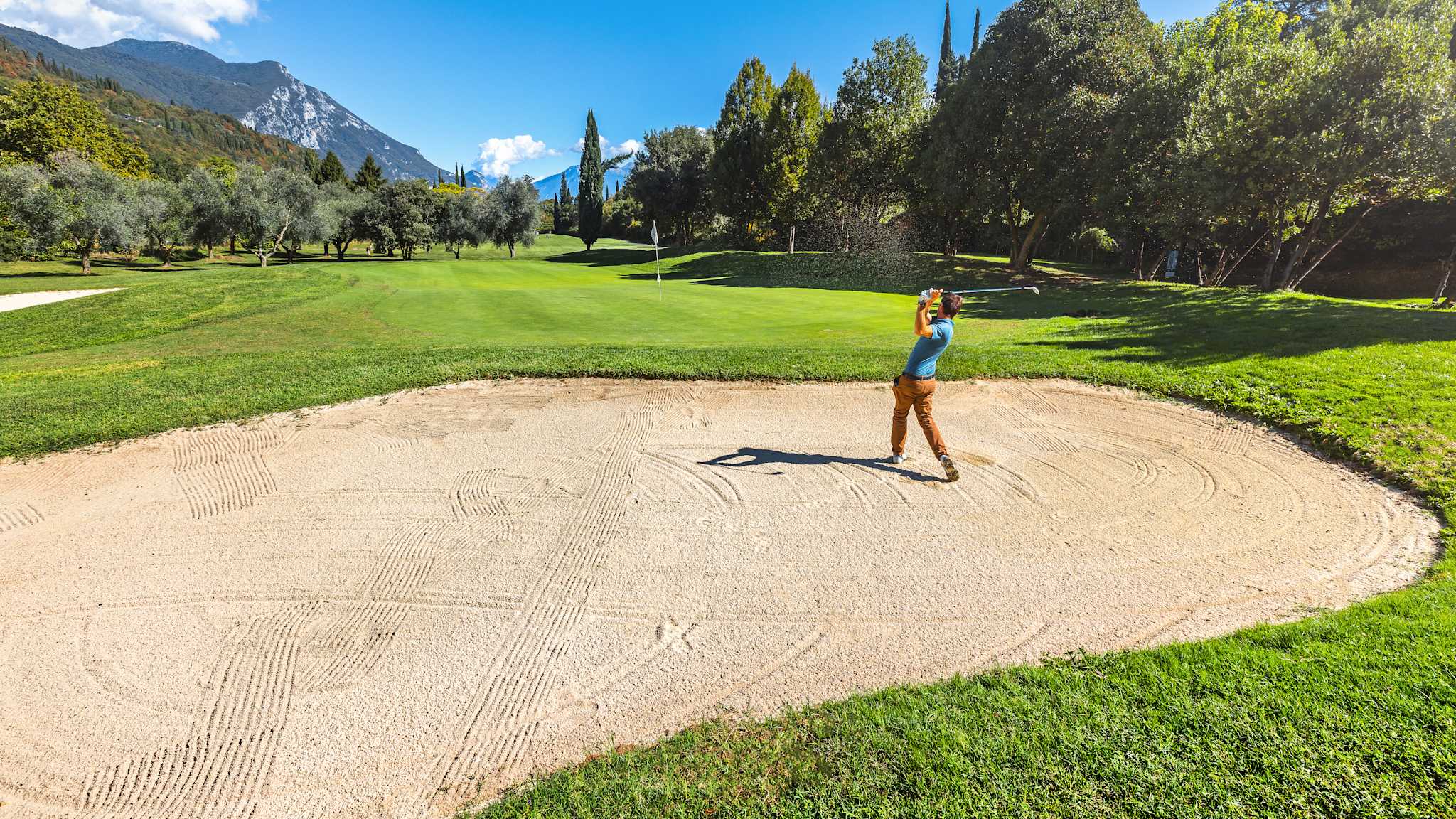 Ein Mann beim Abschlag aus einer Sandgrube