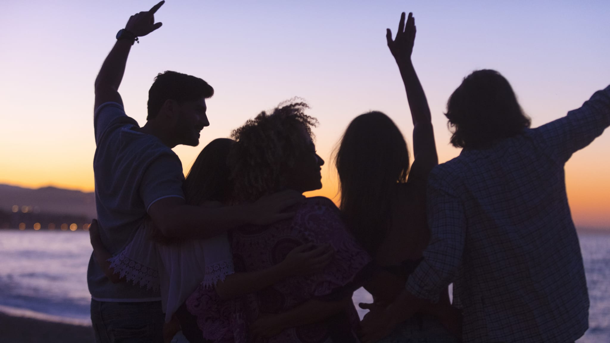 Gruppe feiert am Strand © courtneyk/E+ via Getty Images