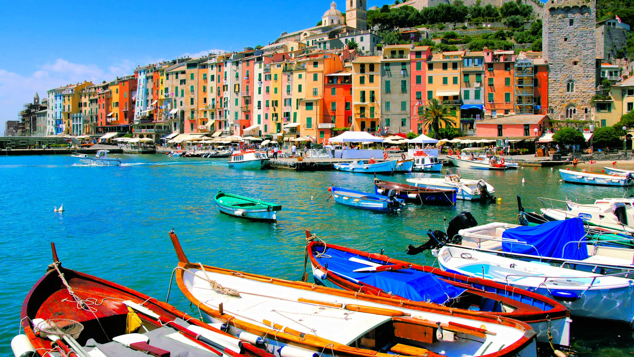 Der Hafen von Portovenere mit bunten Häuserfronten und bunten kleinen Booten.
