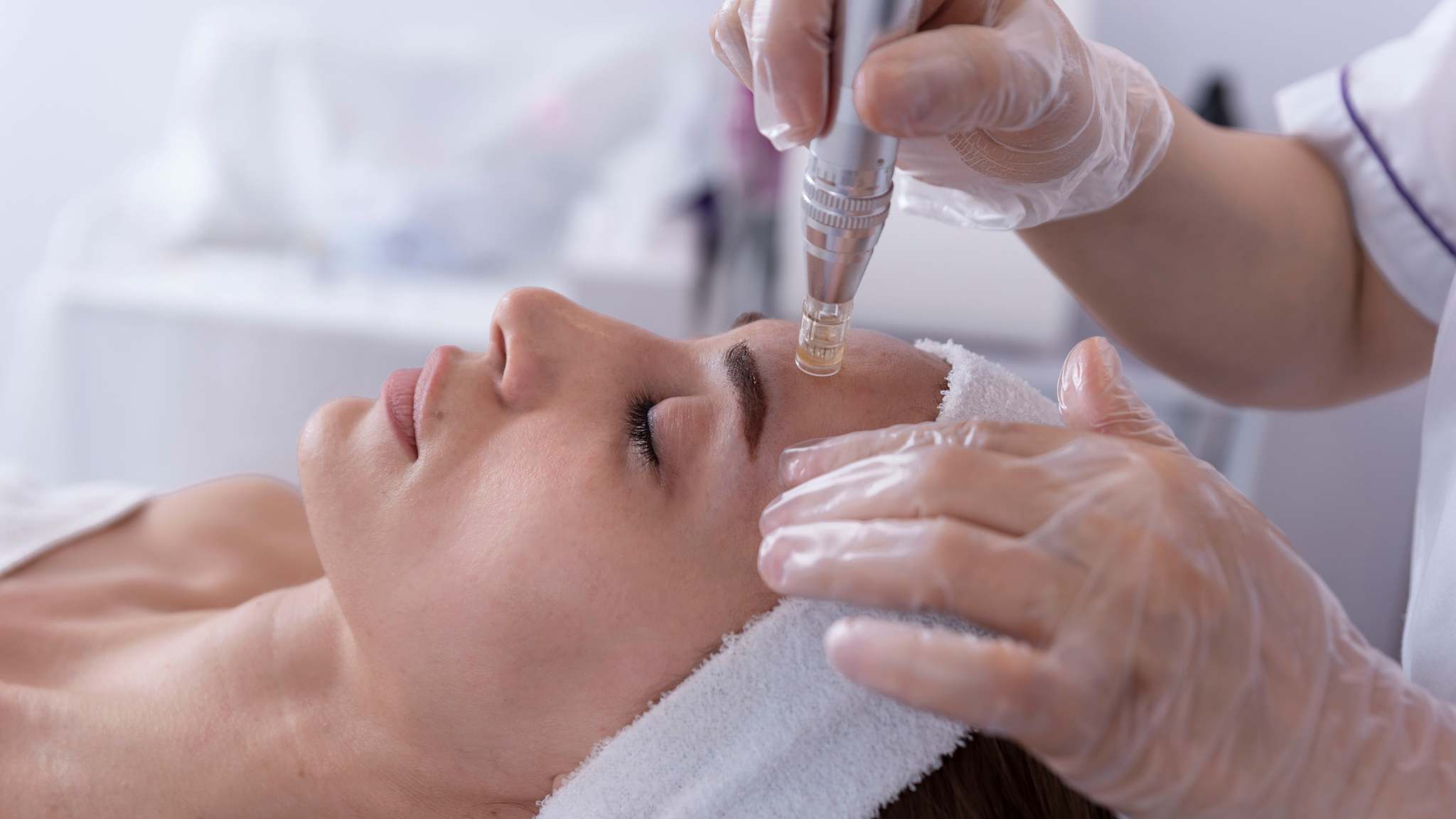 Das Gesicht einer Frau wird bei einer Wellnessbehandlung mit einem Gerät behandelt