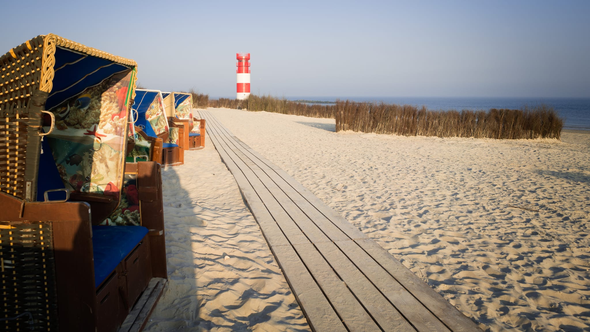 Strandkörbe am Strand mit Holzweg auf der Helgoland-Düne in Schleswig-Holstein