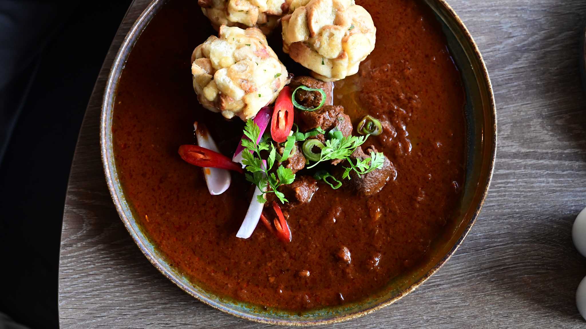 Ein Teller mit tschechischem Rindergulasch mit Knödeln.