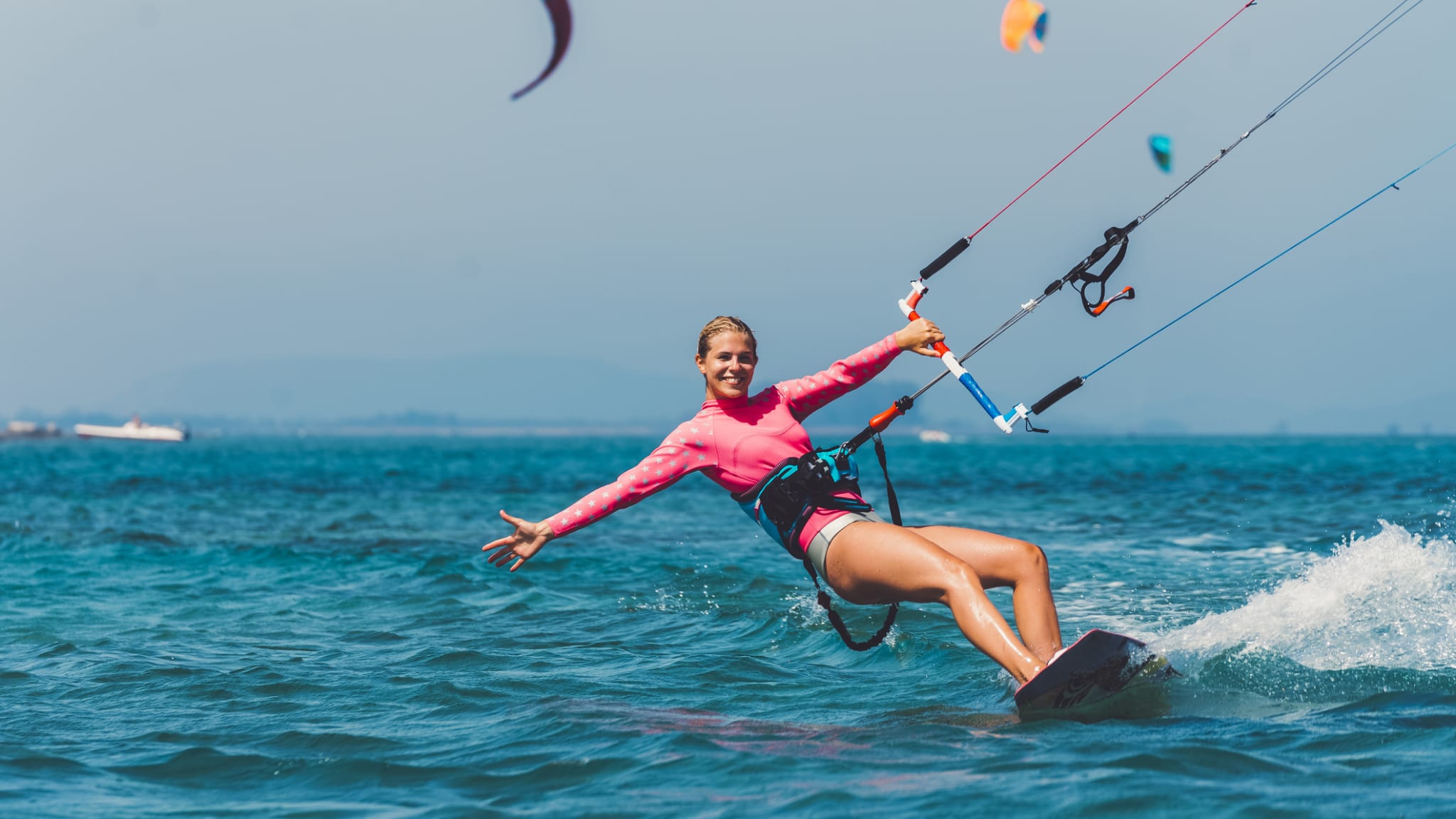 Junge Kiteboarderin auf dem Wasser hat Spaß © iStock.com/Ziga Plahutar