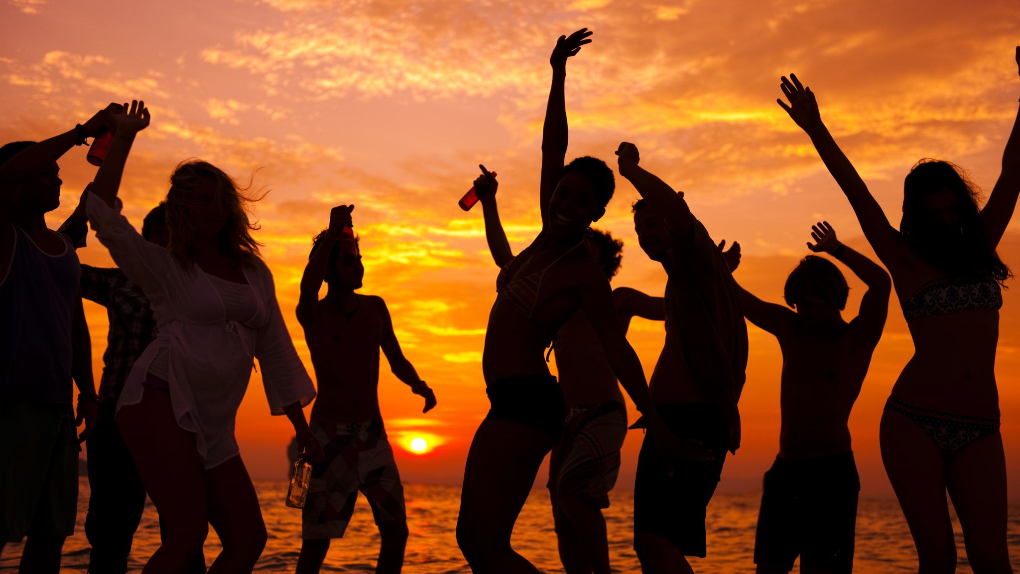 Gruppe beim Tanzen bei Sonnenuntergang