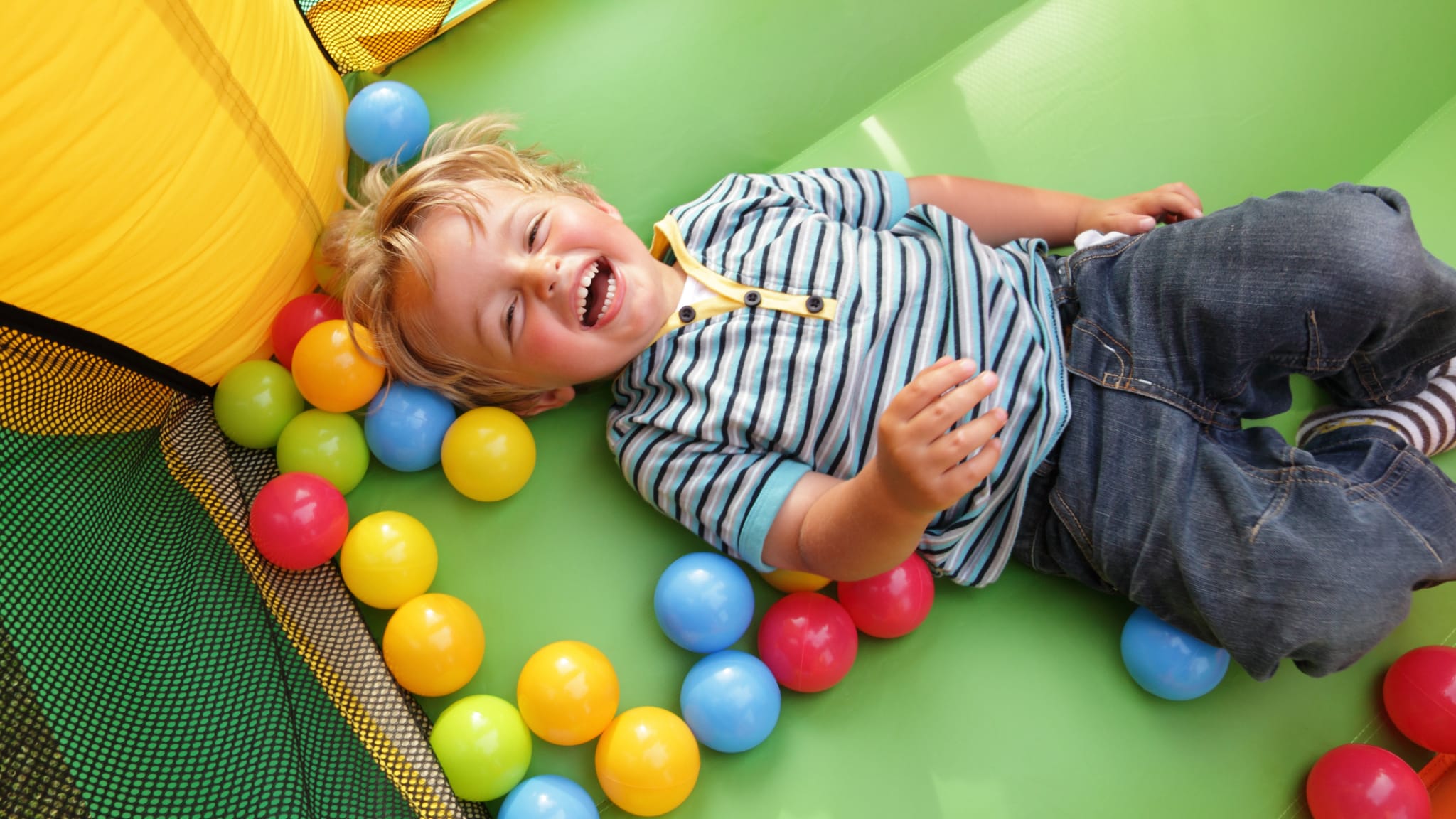 Glückliches Kind in Hüpfburg © stock.adobe.com - Brian Jackson