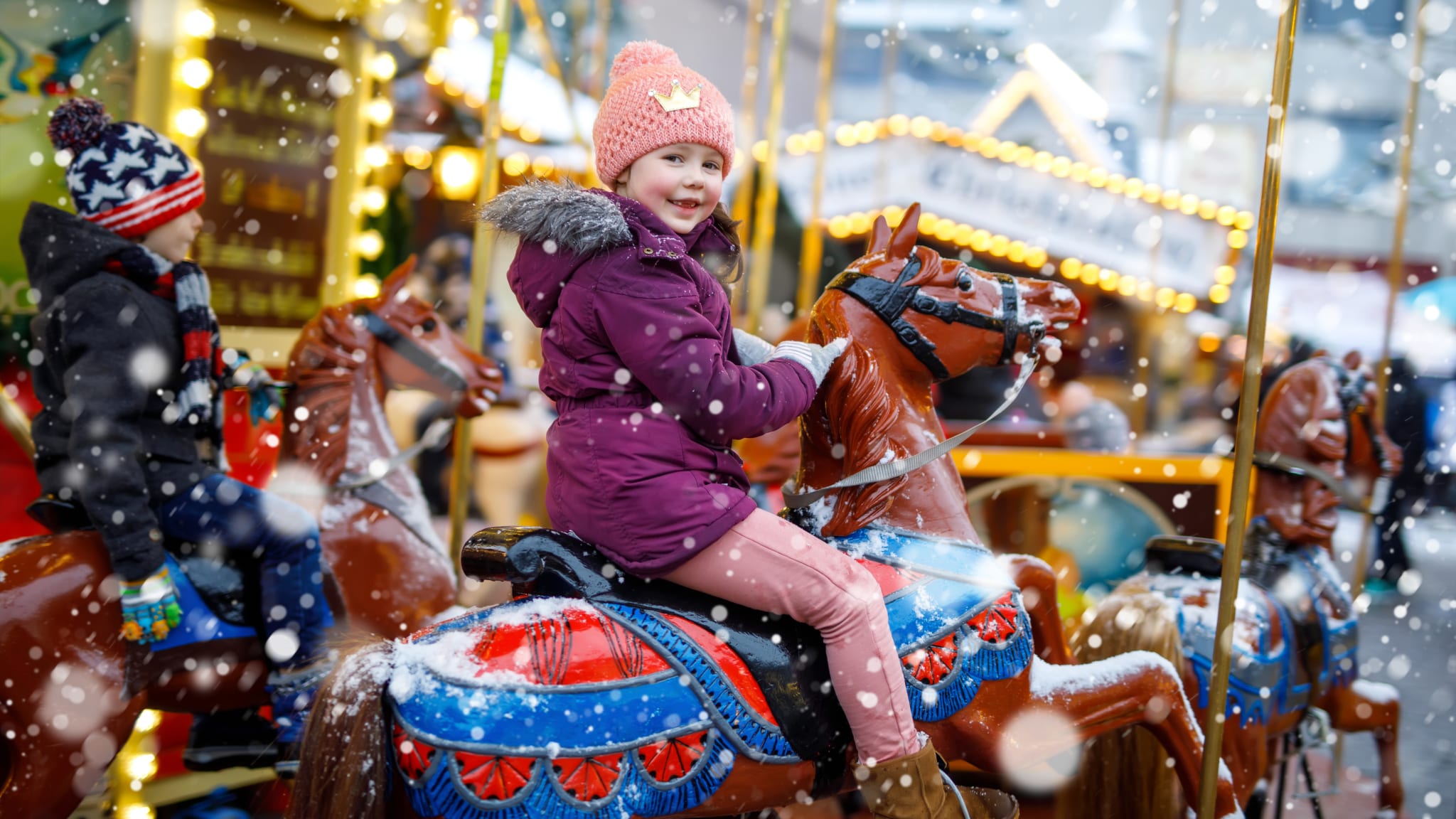Kleines Mädchen auf einem Karussel Pferd auf einer Kirmes©/ romrodinka/iStock / Getty Images Plus via Getty Images