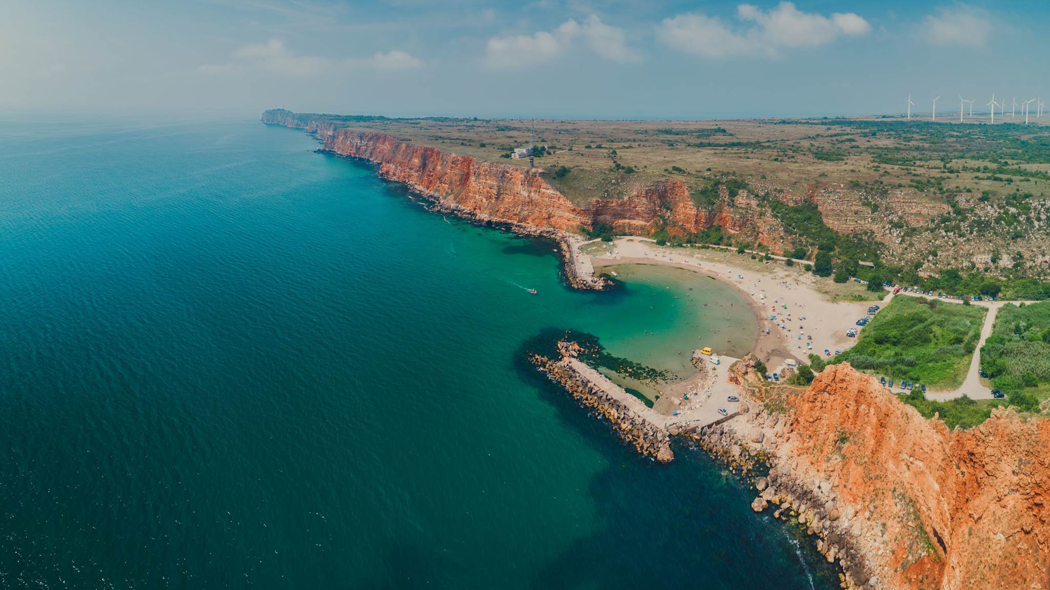 Luftaufnahme des Bolata-Strands mit geschwungener Bucht, Sandstrand und roten Klippen am Kap Kaliakra in Bulgarien