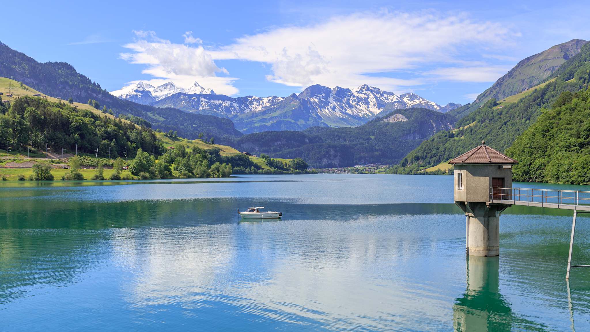 See mit Boot und Bergen im Hintergrund