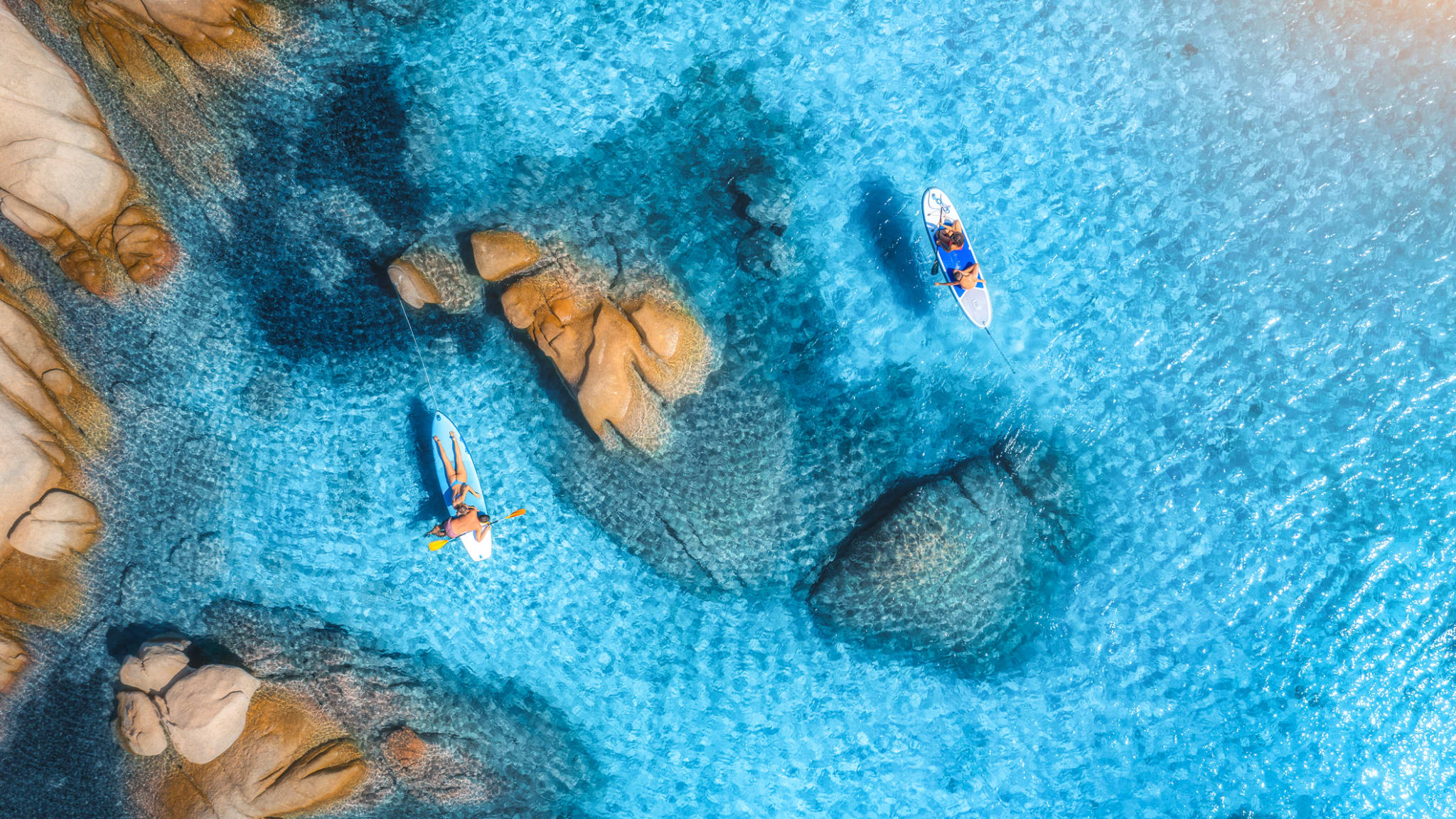 Menschen auf schwimmendem Kanu im transparenten azurblauen Wasser, Insel Sardinien © iStock.com/den-belitsky