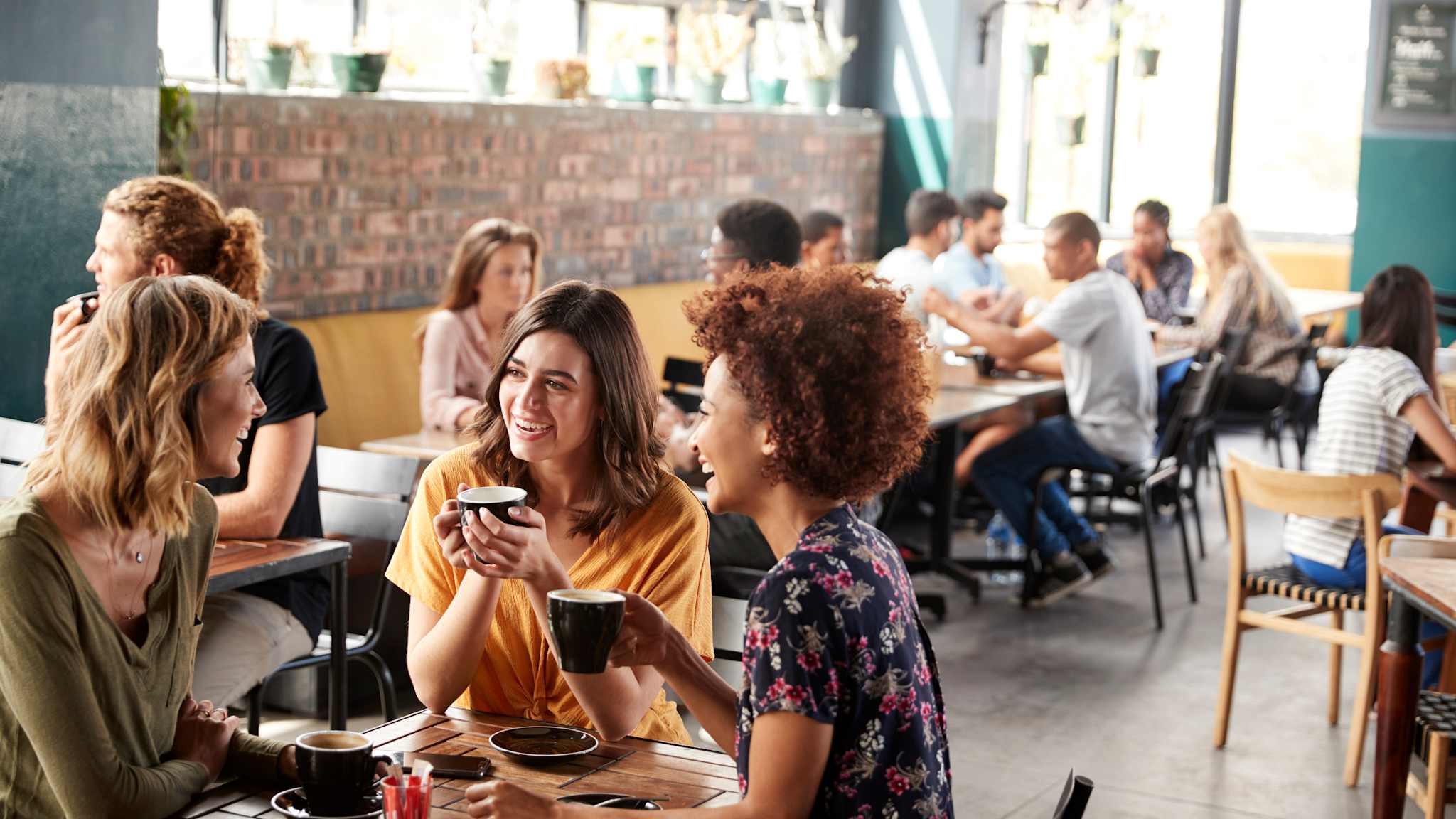 Viele Menschen sitzen in einem Café.