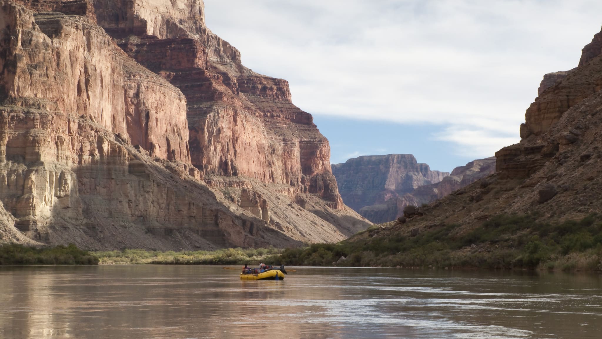 Menschen in einem Schlauchboot treiben im Grand Canyon den Fluss hinunter © iStock.com/bruceman