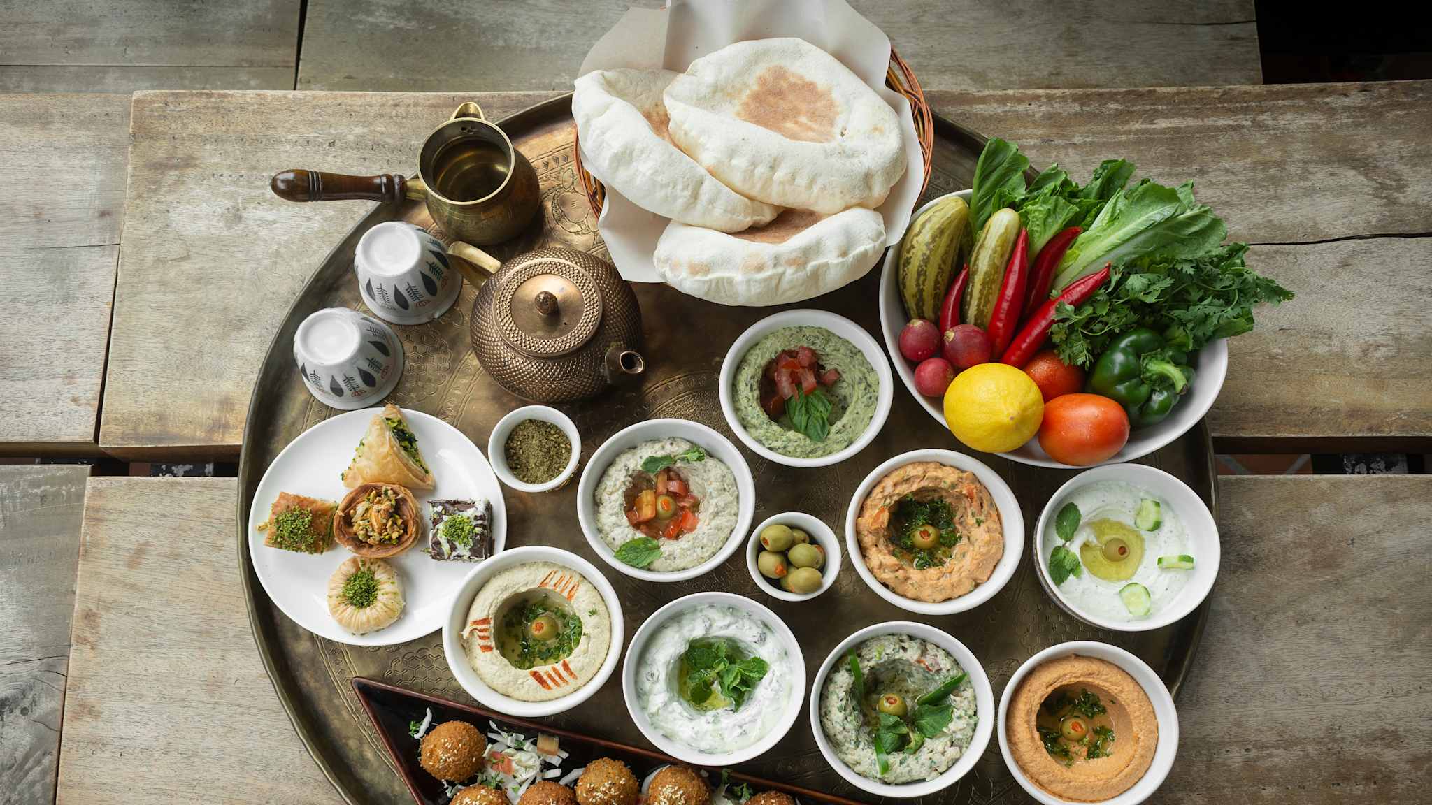 Tablett mit vielen kleinen Schälchen mit Dip, Gemüse, Brot, Tee