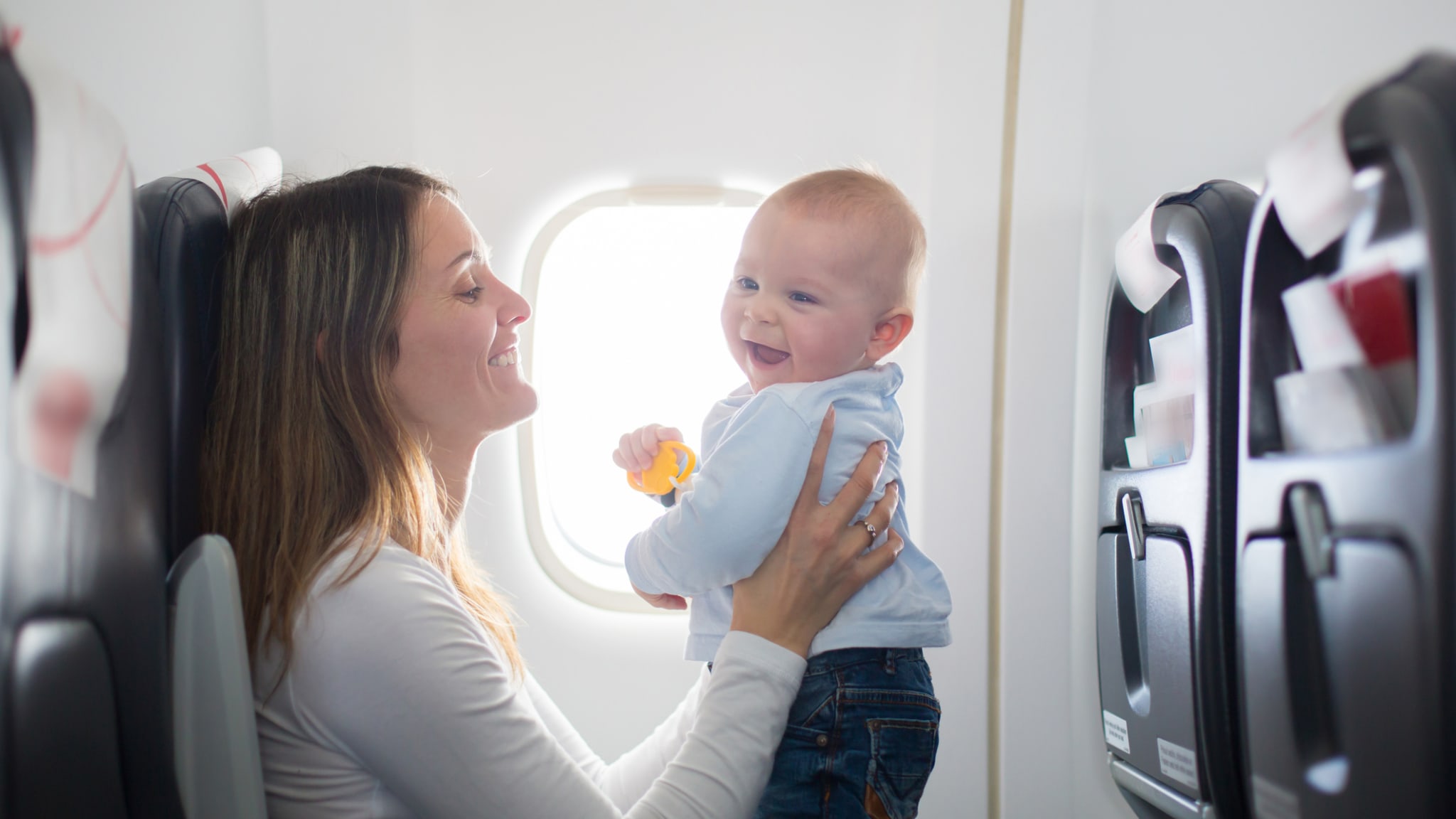 Junge Mutter spielt mit ihrem Kleinkind im Flugzeug ©tatyana_tomsickova/iStock