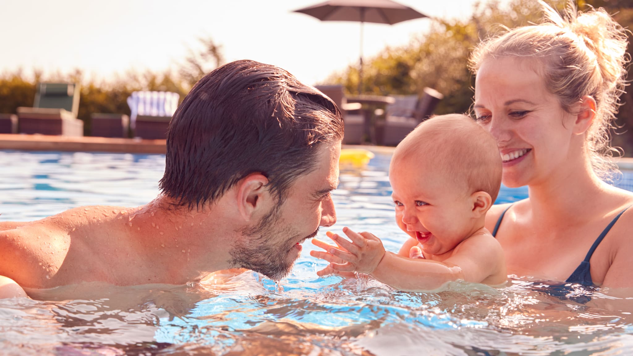 Mutter und Vater haben Spaß mit Baby im Pool © iStock.com/monkeybusinessimages
