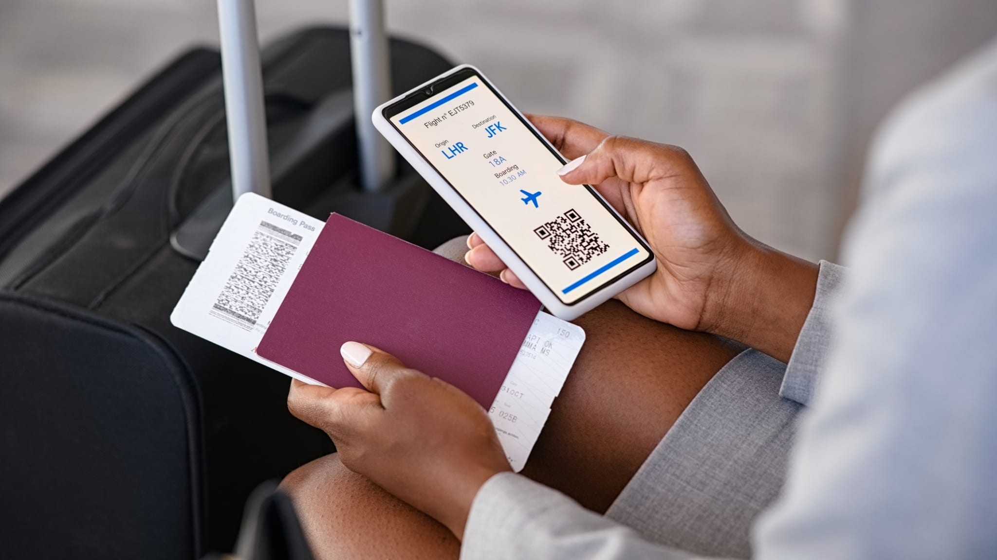 Nahaufnahme einer Geschäftsfrau, die das Flug-E-Ticket am Flughafen überprüft © iStock.com/Ridofranz